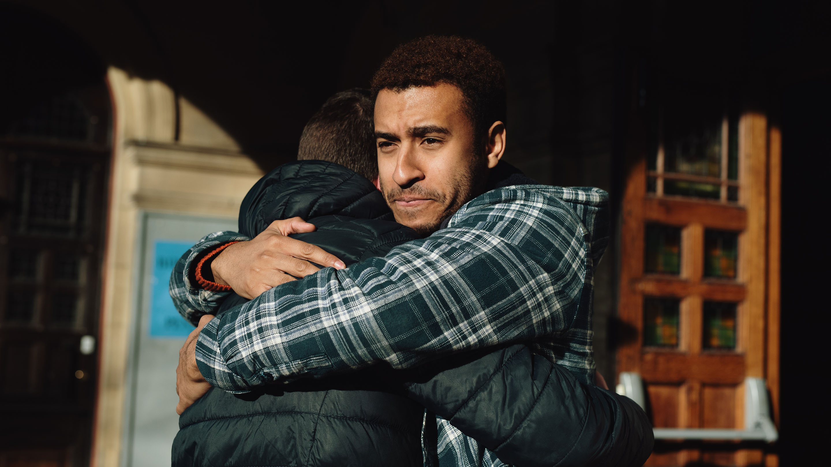 Two men hugging and supporting each other