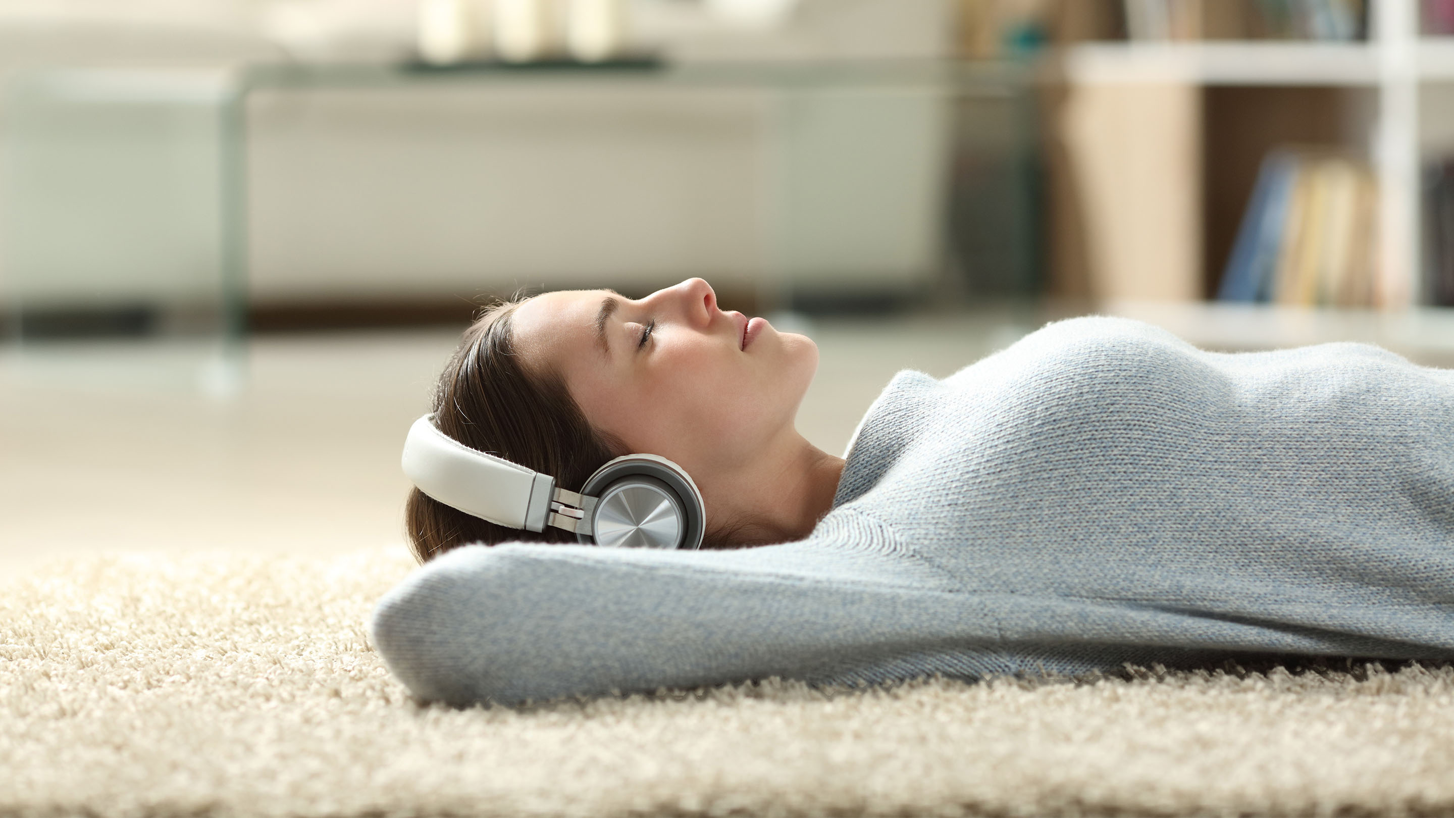 Woman lying down listening to audio