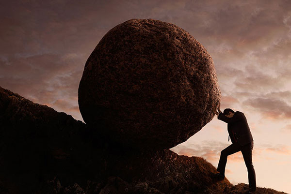 a man pushing a big rock up a hill (Sisyphus)
