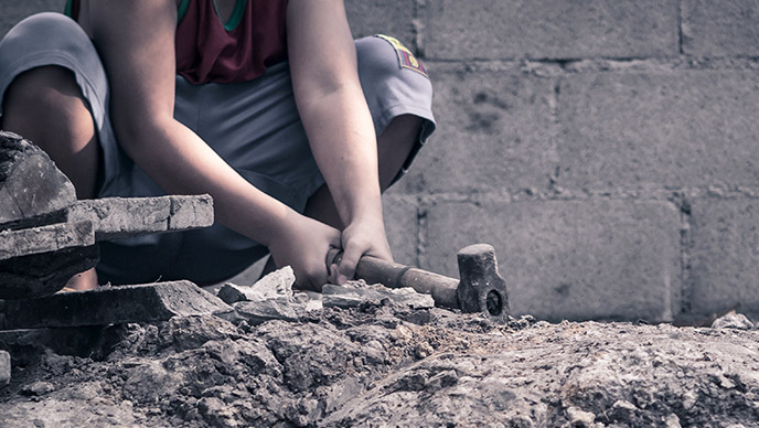 Child labour concept: boy working at construction site