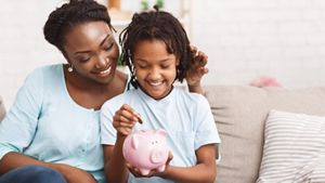 Mother and daughter with a piggy bank