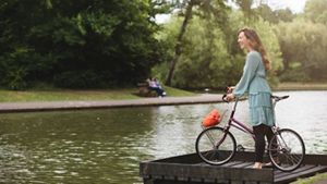 Woman on bike near a lake