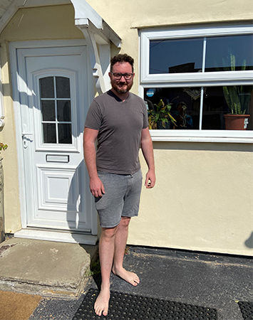 person standing outside a house smiling