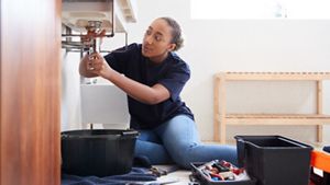 Woman fixing sink
