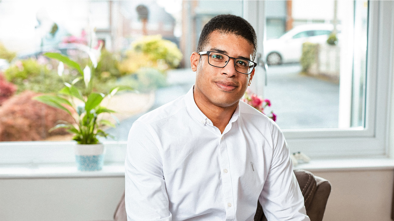 A portrait of Lee Chambers sitting on a chair