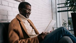 Man wearing smart clothes sitting with a book