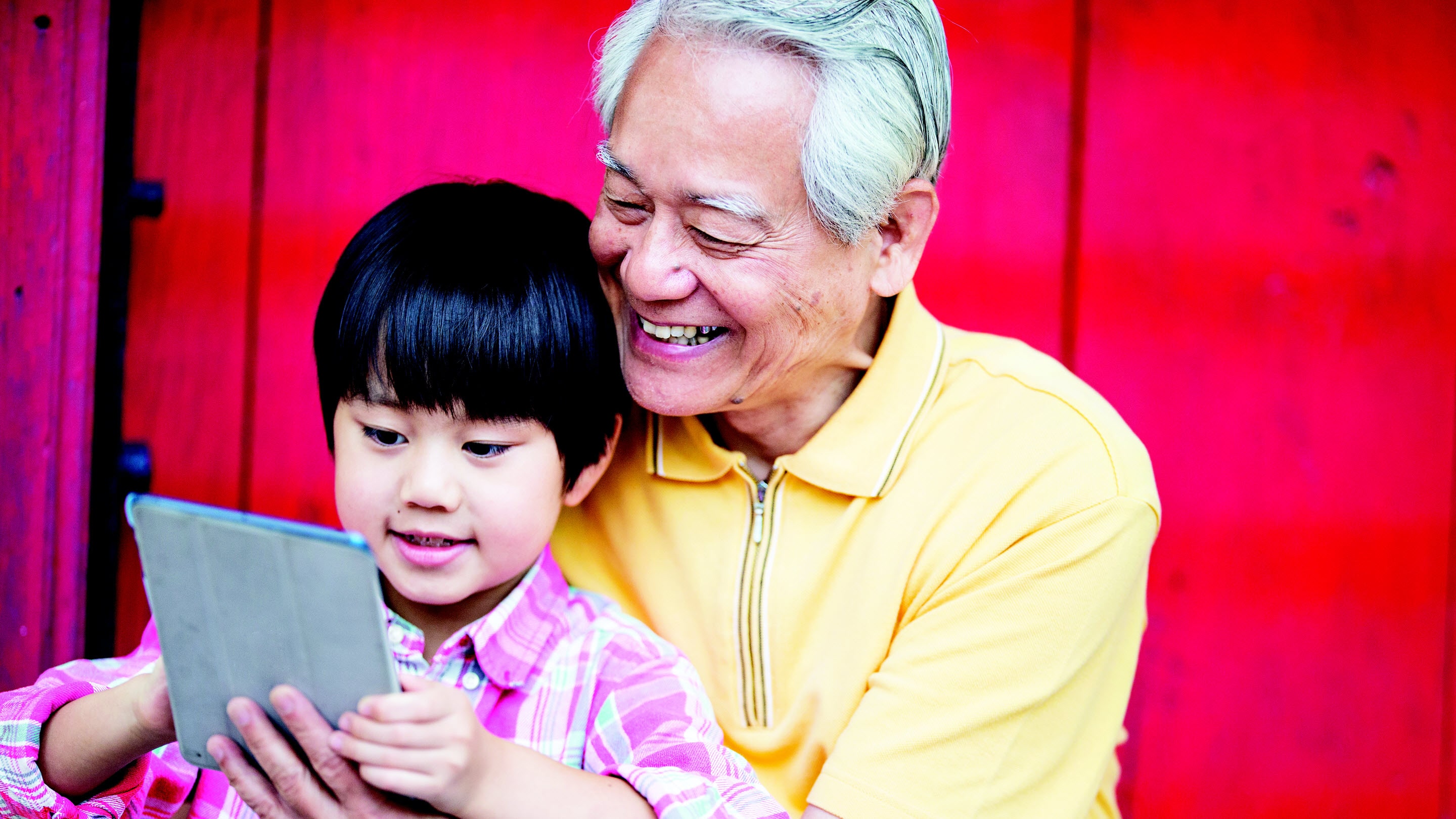 Grandson showing grandfather his tablet