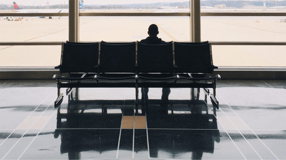 Person waiting in airport following news of airspace closure
