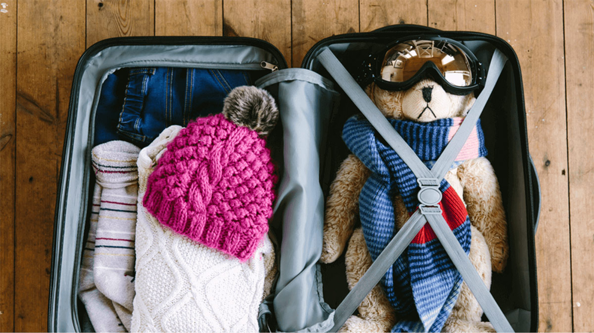 Child's luggage depicting scarf, hat, socks and a teddy bear