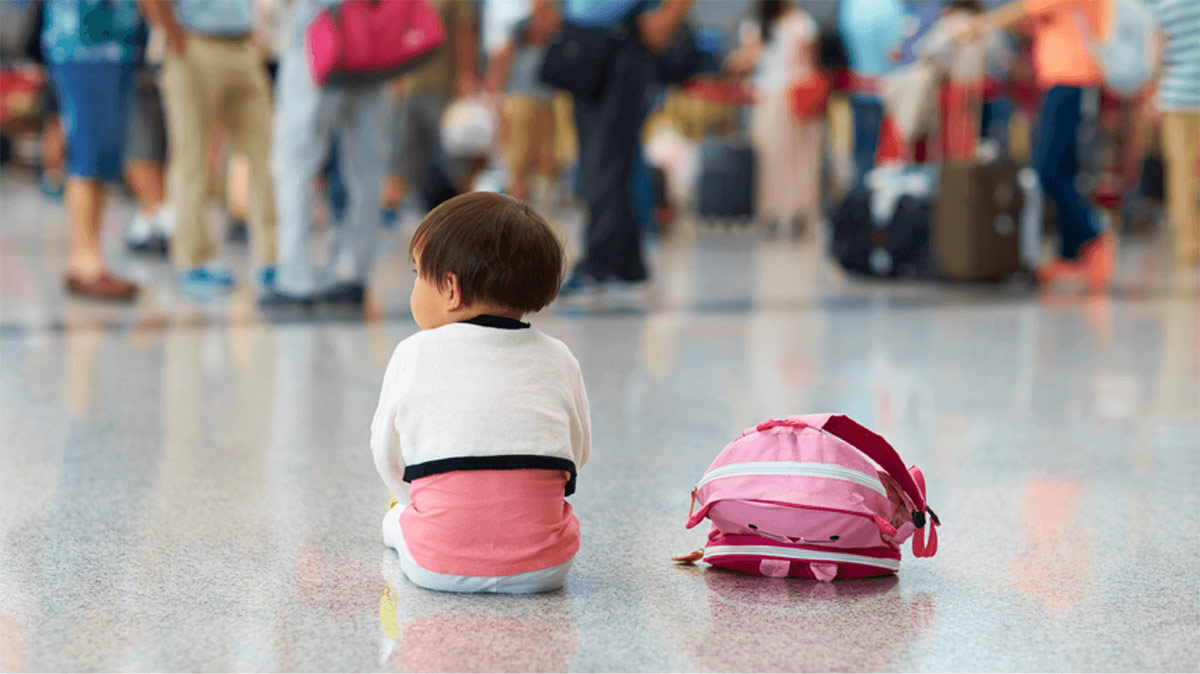 Child waiting in airport terminal during travel disruption