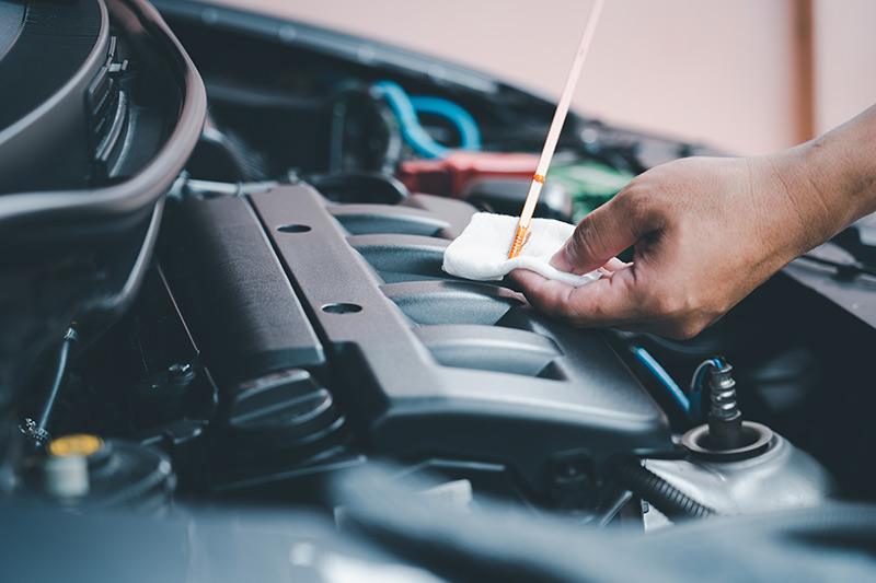 Common Car Leaks - Mechanic looking under bonnet for a potential leak