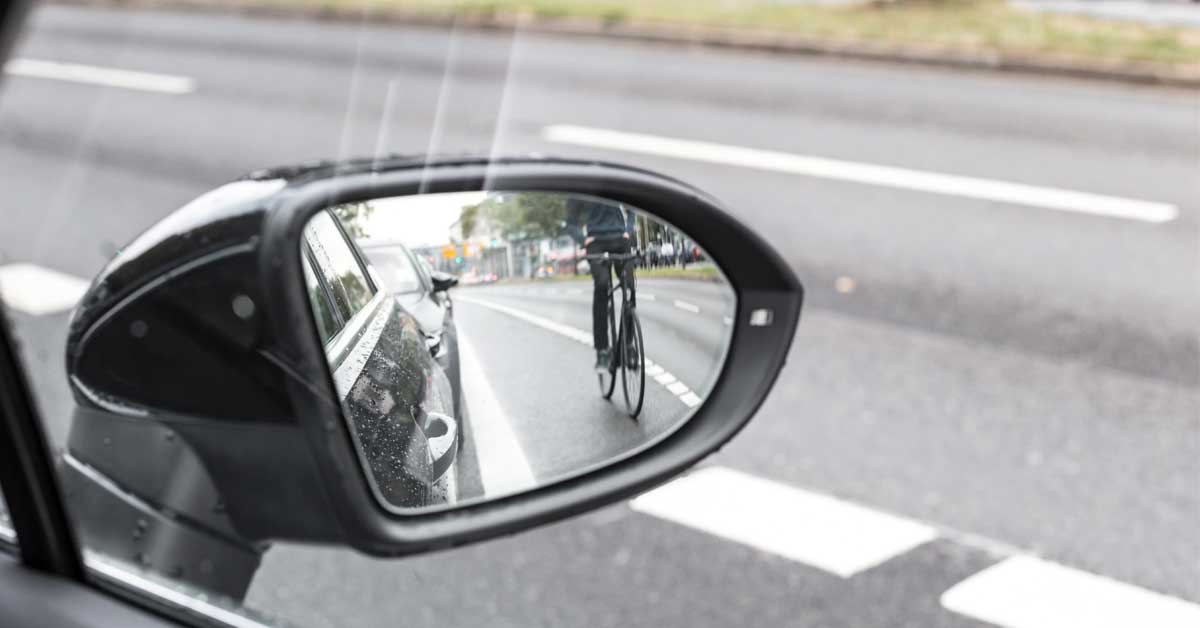 Cyclist in car side mirror