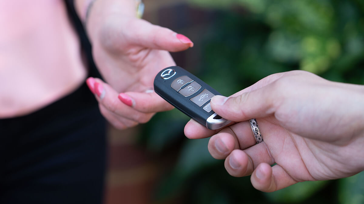 Improve car resale value – Female and male hands passing car keys