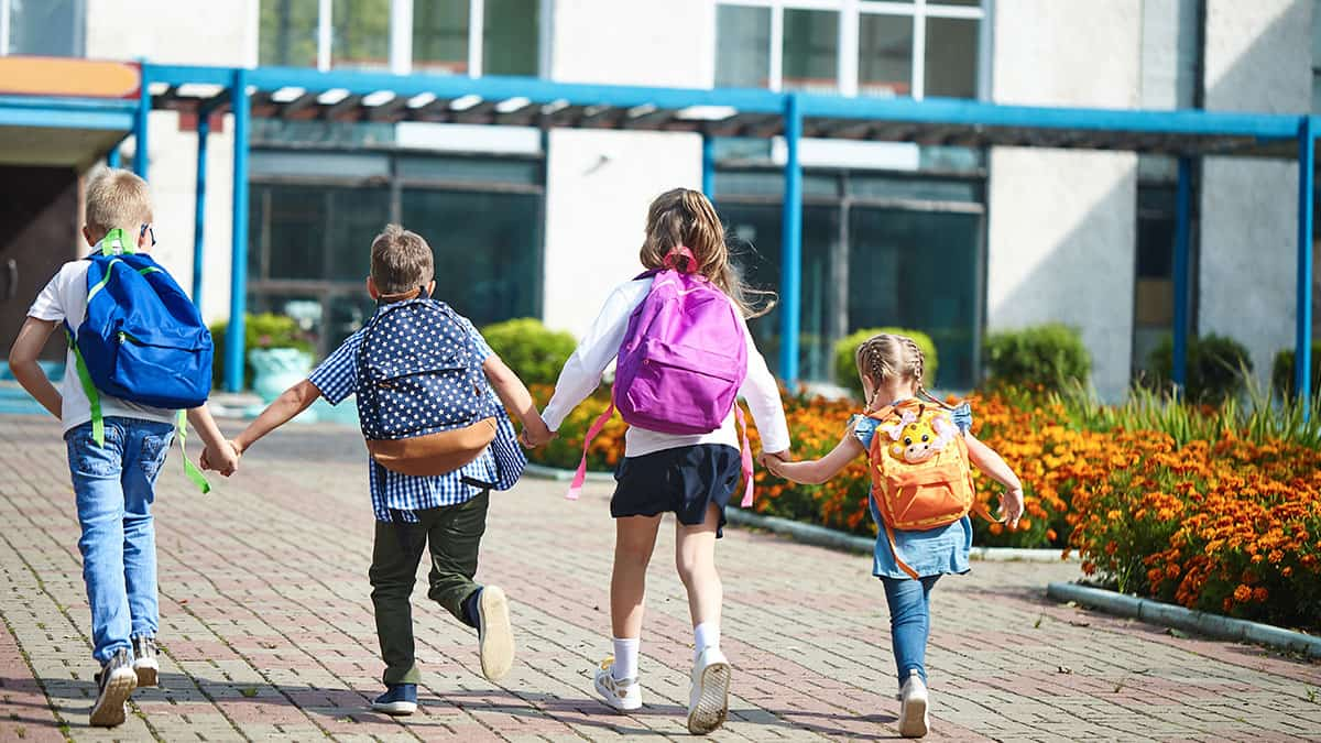 Children going to school holding hands they got there via a carpool for school