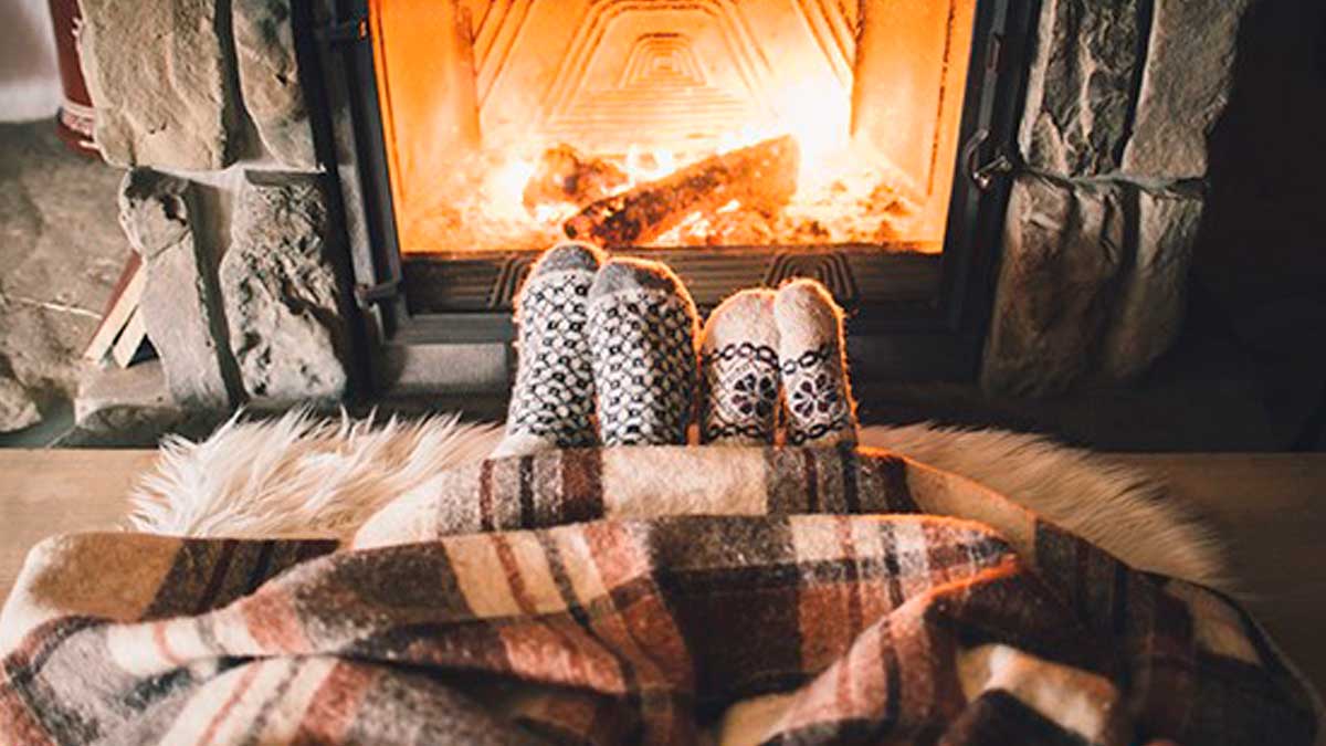 Christmas fire safety tips – image of 2 pairs of feet cosy in front of a fire