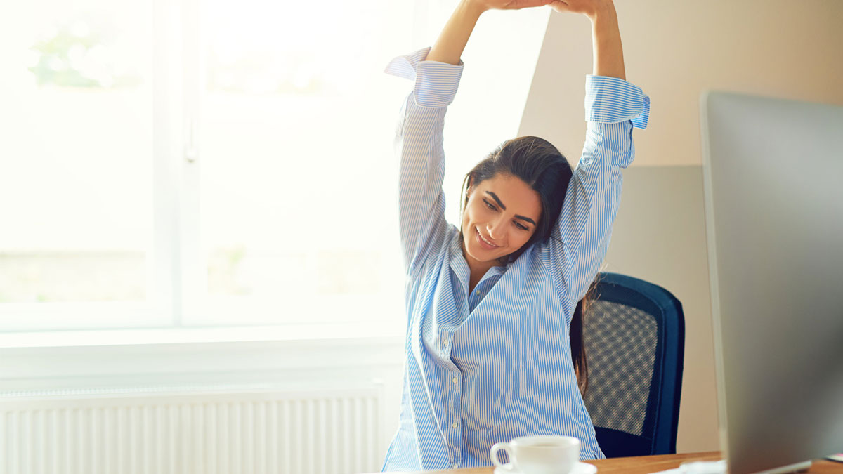 Lady stretching at her home desk