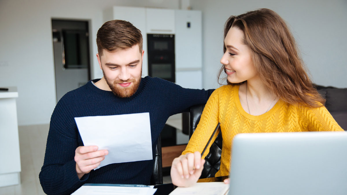 Couple happy applying for their mortgage after saving for their house deposit