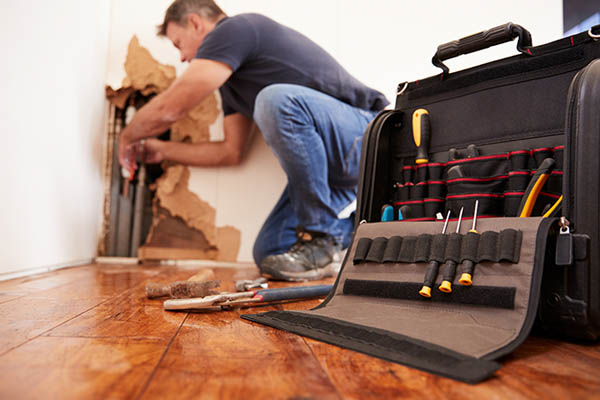 Plumber fixing a burst pipe in the home