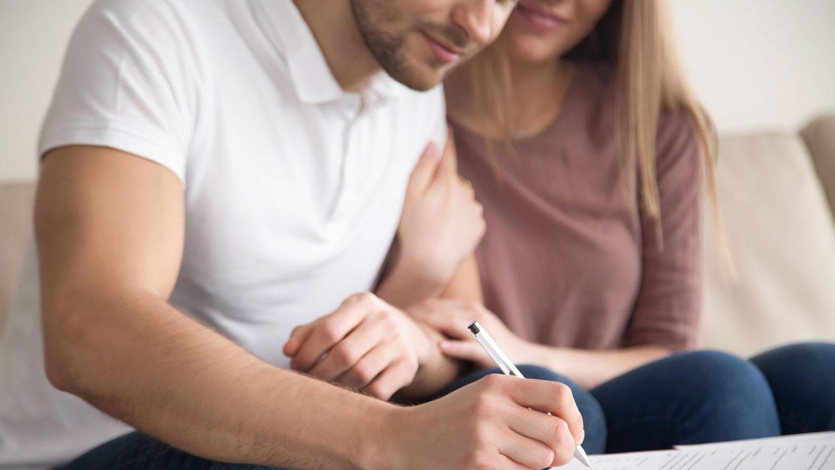 Couple smiling reviewing their mortgage protection insurance checklist
